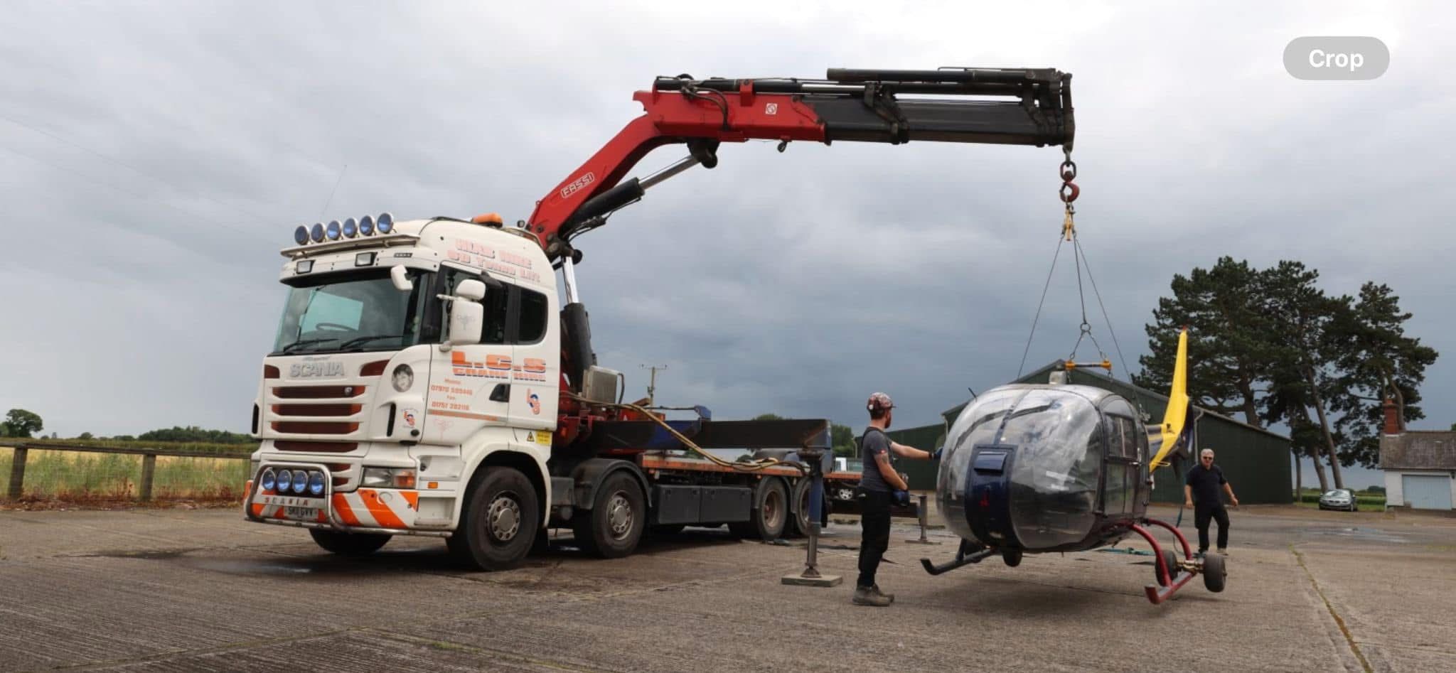 Vehicle-mounted crane lifting helicopter load
