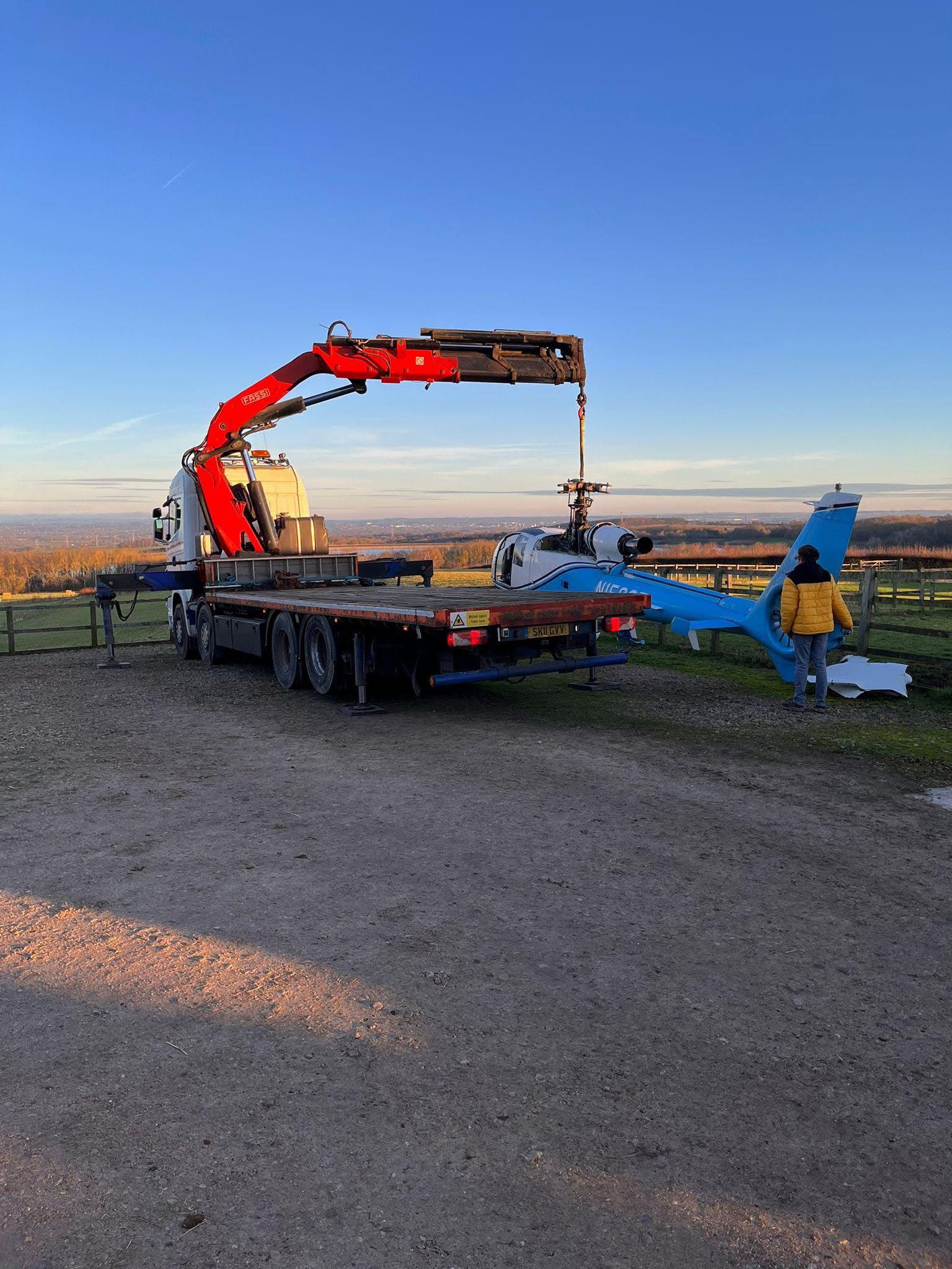 Vehicle-mounted crane lifting helicopter load